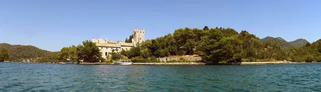 Het kloostereilandje met zijn stenen toren midden in het Veliko jezero op Mljet Het kloostereilandje met zijn stenen toren midden in het Veliko jezero op Mljet