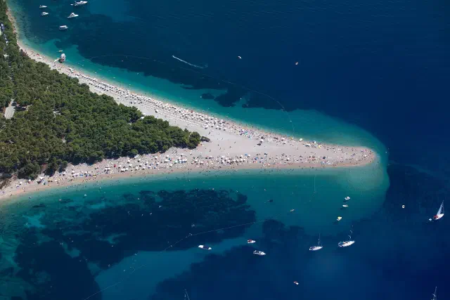 Zlatni Rat in Bol, het beroemde kiezelstrand met de driehoekige punt in zee Zlatni Rat in Bol, het beroemde kiezelstrand met de driehoekige punt in zee