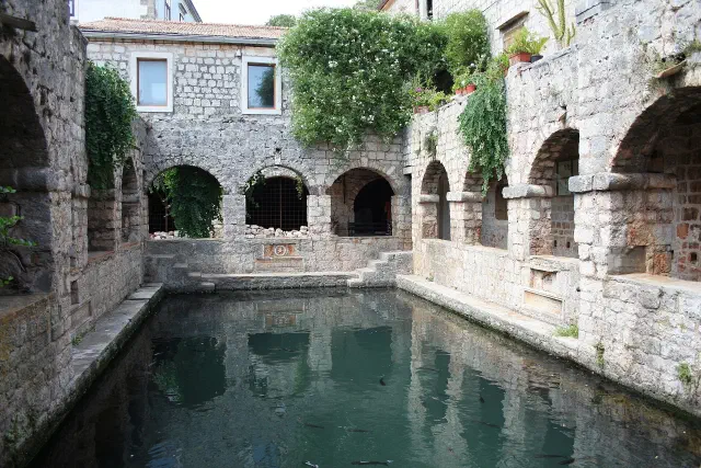 Het Tvrdalj-kasteel met de ommuurde visvijver in Stari Grad Het Tvrdalj-kasteel met de ommuurde visvijver in Stari Grad